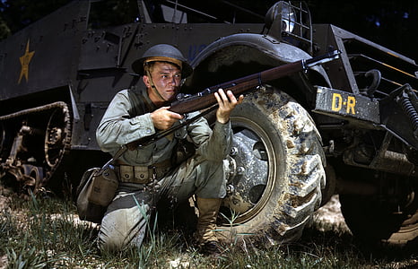 man wearing black kevlar helmet holding rifle thumbnail