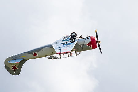 gray and red plane flying on sky thumbnail