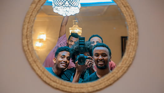 group of people taking photo of themselves in the mirror thumbnail