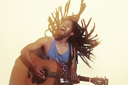 man in blue tank top playing brown acoustic guitar thumbnail