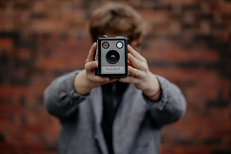 selective photography of men holding gray device thumbnail