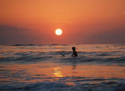 silhouette photography of person surfing thumbnail