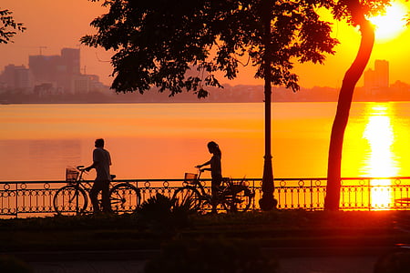 man and woman holding their bikes while walking thumbnail