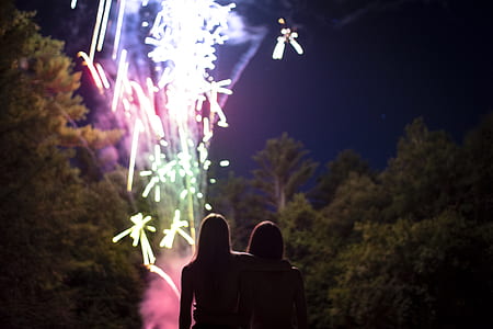 two women watching fireworks at nighttime thumbnail