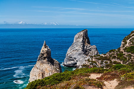 gray rock formation next to ocean water thumbnail