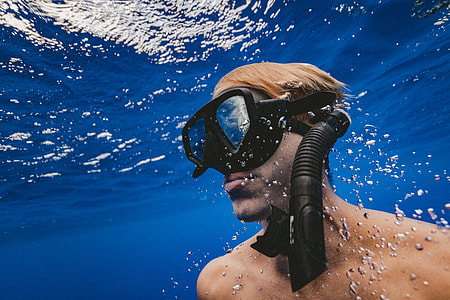 man in black underwater goggles and snorkel in body of water thumbnail