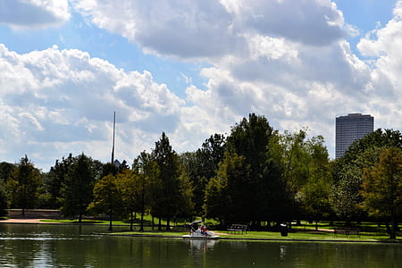 grey calm body of water near trees and buildings thumbnail
