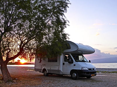 white caravan parked beside tree thumbnail