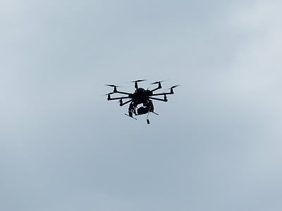 black drone flying at daytime thumbnail