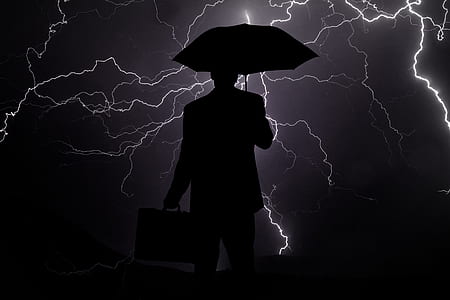 silhouette of man holding briefcase and umbrella thumbnail
