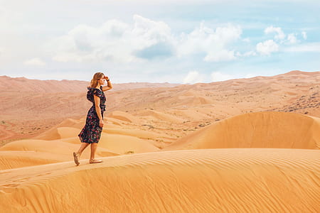 woman standing on brown sand pile thumbnail