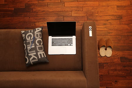 silver MacBook on brown couch thumbnail