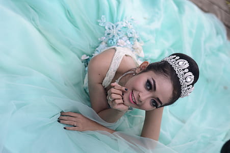 Woman Wears Teal Chiffon Gown and Crown thumbnail