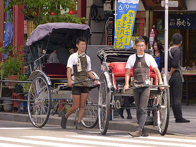 two man carrying carriage on gray road during daytime thumbnail