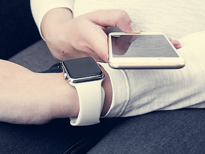 person holding gold iPhone and space gray aluminum case Apple Watch with white Sport Band thumbnail