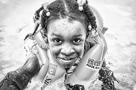 grayscale photography of toddler girl in body of water thumbnail