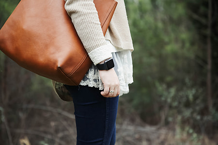 person standing carrying handbag near plants thumbnail