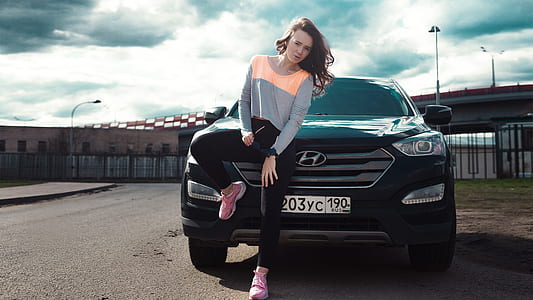 woman lining on black Hyundai car thumbnail