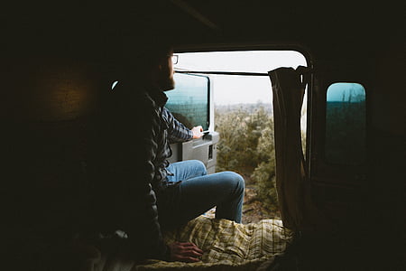 man sitting on vehicle while opening door and looking outside thumbnail
