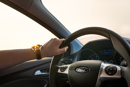 person holding gray Ford car steering wheel during daytime thumbnail