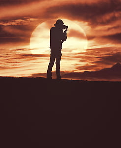 silhouette photograph of person using DSLR camera thumbnail