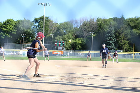 A group of adults playing a baseball game in the day time thumbnail