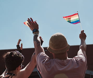 two person holding pride flags during daytime thumbnail