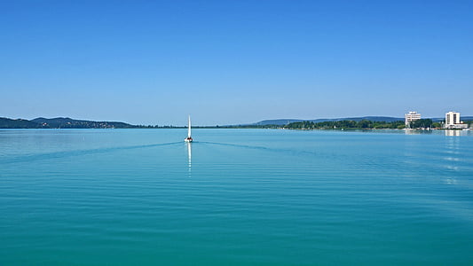white boat on water near coastline thumbnail