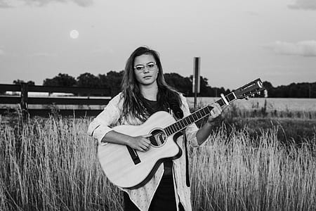 woman holding guitar surrounded with plants thumbnail