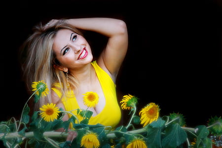 woman wearing yellow scoop-neck sleeveless top in front of sunflowers thumbnail