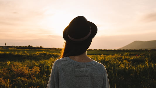 woman wearing brown hat on grass field at day time thumbnail