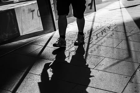 grayscale photography of person standing on pavement thumbnail