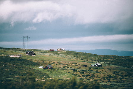 houses on green field under cloudy sk thumbnail