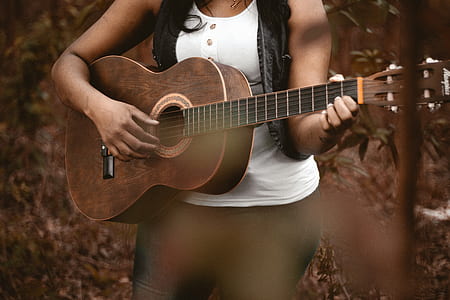 woman playing acoustic guitar on focus photo thumbnail