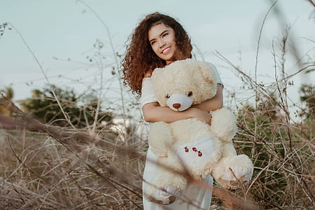 woman carrying yellow and white bear plush toy thumbnail