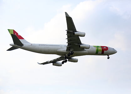 low-angle photography of white, green, and red passenger plane with opened landing gear while inflight thumbnail