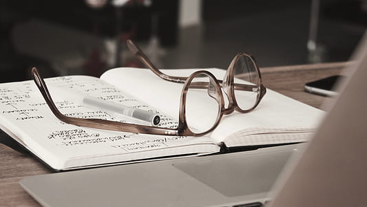 brown framed eyeglasses above of notebook thumbnail