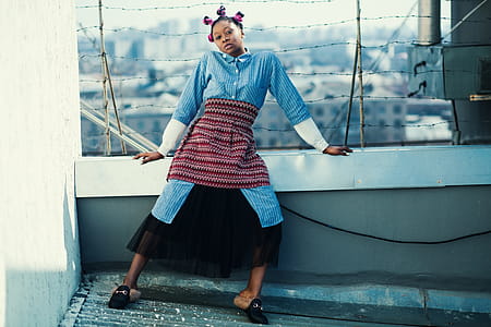 Woman Wearing Blue and Black Long-sleeved Jumpsuit Standing on Roof thumbnail