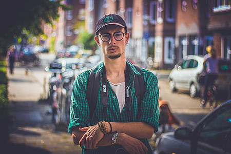 man wearing green shirt standing near black vehicle thumbnail