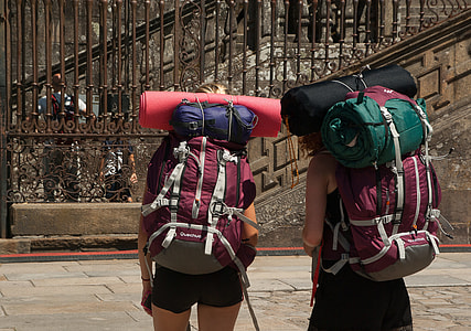 two person carrying hiking backpack and mats thumbnail