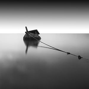 grayscale photography of boat on sea during daytime thumbnail