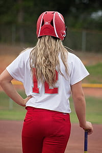 woman wearing baseball uniform holding baseball bat thumbnail