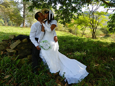 man and woman kissing while sitting on wood piles thumbnail