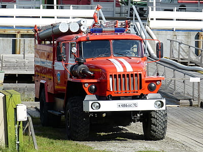 red Firetruck near gray building during day time thumbnail