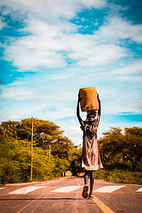 selective focus photography of person holding basket while waking on road thumbnail