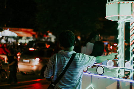 man standing near turned-on string lights thumbnail