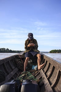 Man Wearing Black Cap Sitting Inside a Boat thumbnail