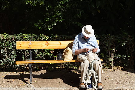 man sitting on wooden bench thumbnail