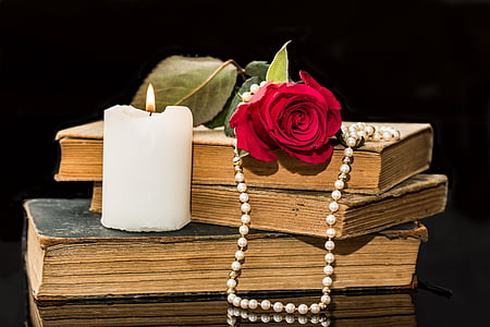 white candle near red rose thumbnail