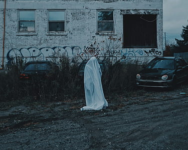 person walking with white textile beside black car thumbnail